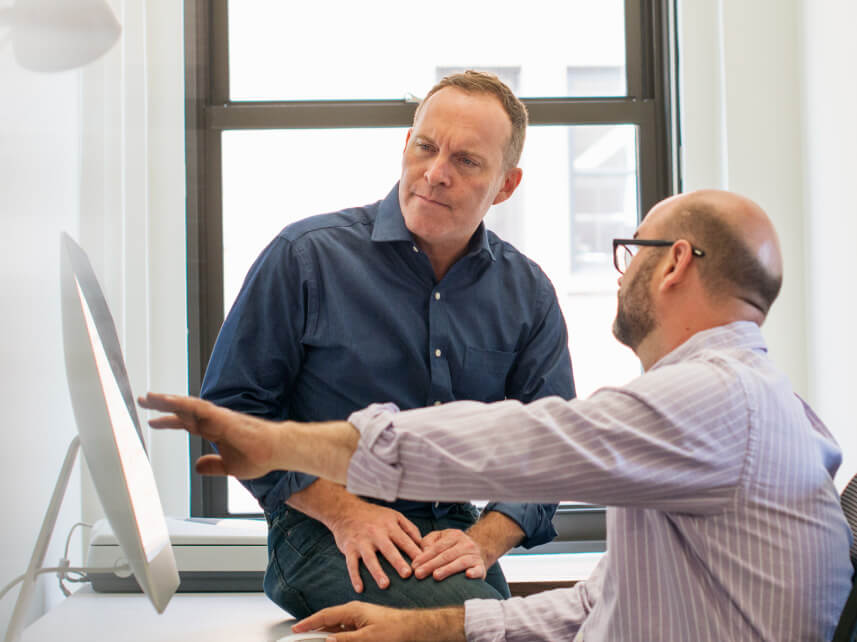 two men looking at a screen